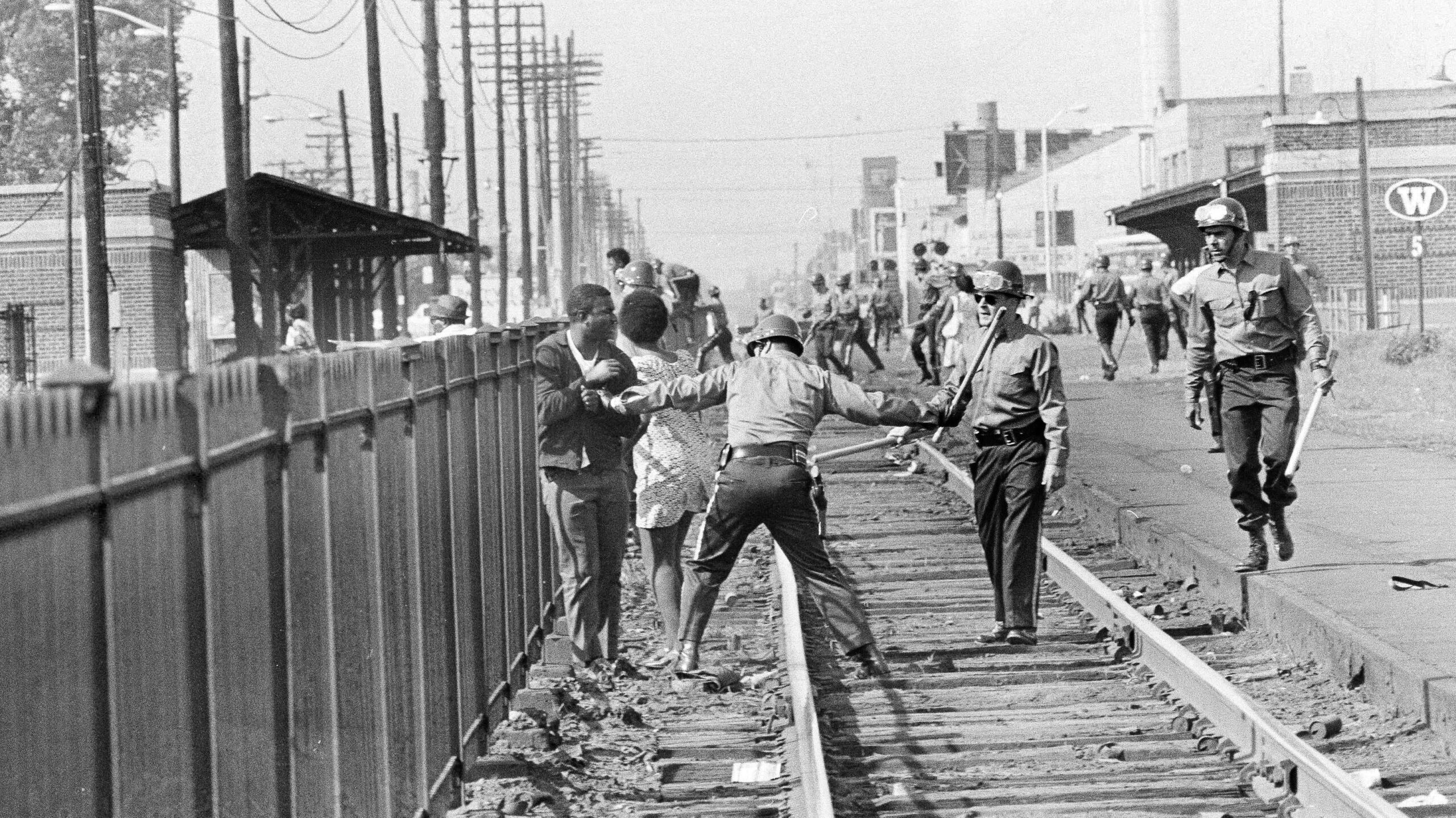 A New Jersey State Policeman winds up to hit an African-American man with a baton who refused to move on during racial disorders near the train tracks in Asbury Park, N.J., July 8, 1970. The police attempted to disperse the rock and firebomb throwing youths with tear gas. (AP Photo/Dave Pickoff) - Associated Press