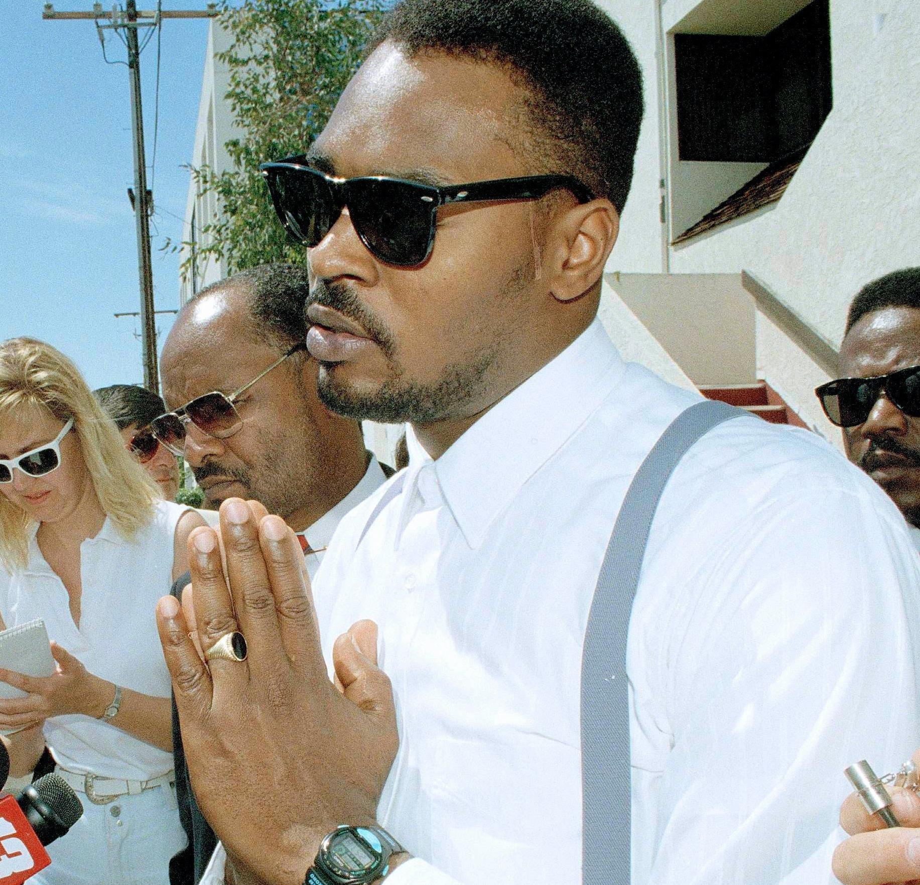 Rodney King makes a point at a news conference in Santa Ana, Calif., June 2, 1994. Jurors who earlier ordered the city of Los Angeles to pay King $3.8 million for his beating declined to order punitive damages against any of the police officers involved in the March 1991 video taped beating. King’s attorney Milton Grimes looks on second from right. (AP Photo/Chris Martinez) - Associated Press