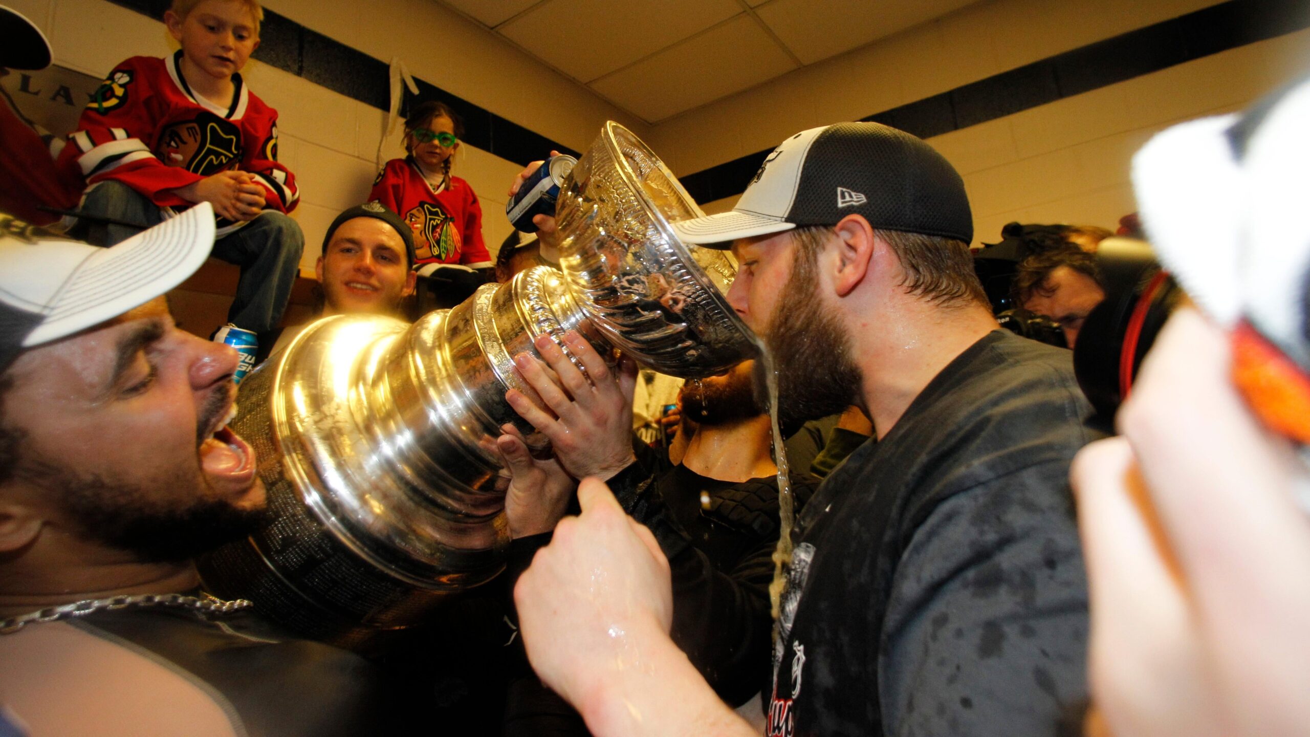 Chicago Blackhawks right wing Dustin Byfuglien, left, holds the the Stanley Cup and Jordan Hendry, right, drinks from it after the Chicago Blackhawks beat the Philadelphia Flyers 4-3 in overtime to win Game 6 of the NHL Stanley Cup hockey finals on Wednesday, June 9, 2010, in Philadelphia. (AP Photo/Matt Slocum) - Associated Press