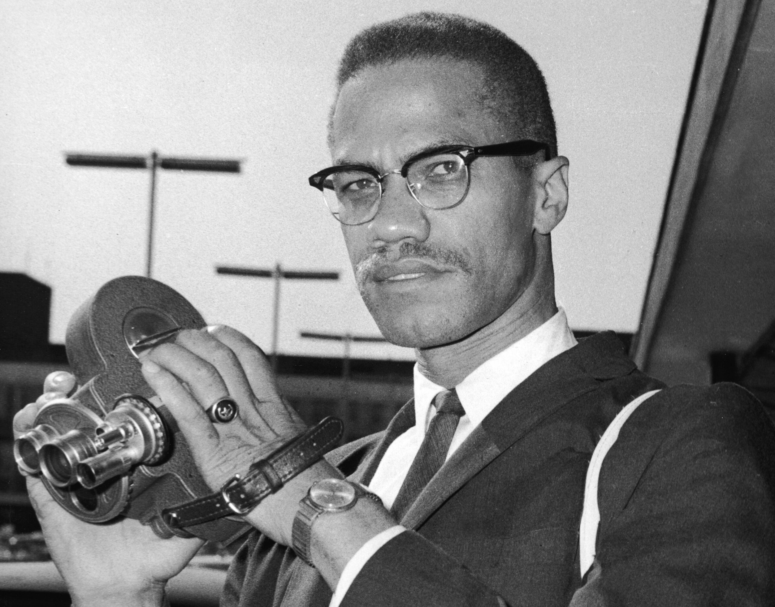 Malcolm X (1925 - 1965) as he holds an 8mm movie camera in London Airport, London, England, July 9, 1964. Photo: Getty Images Express Newspapers